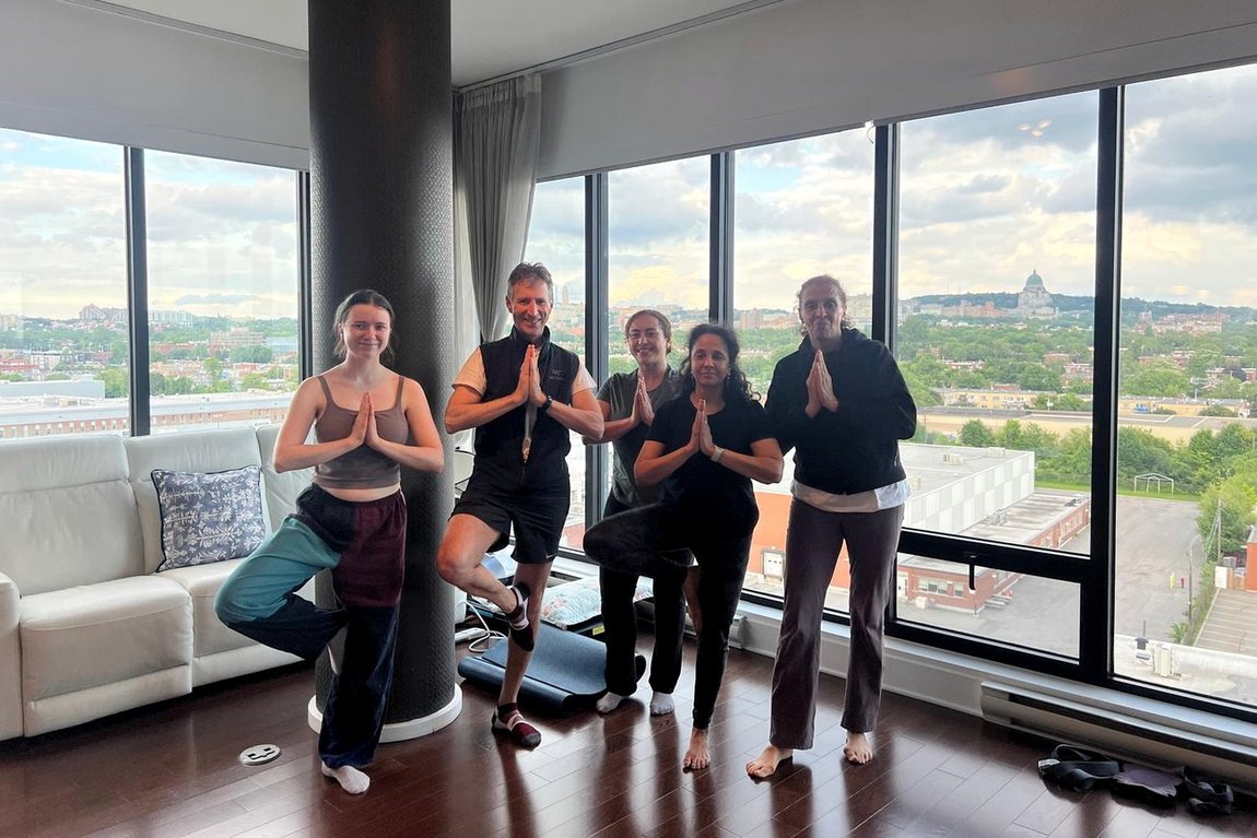A mixed group in tree pose during a class led by Shipra